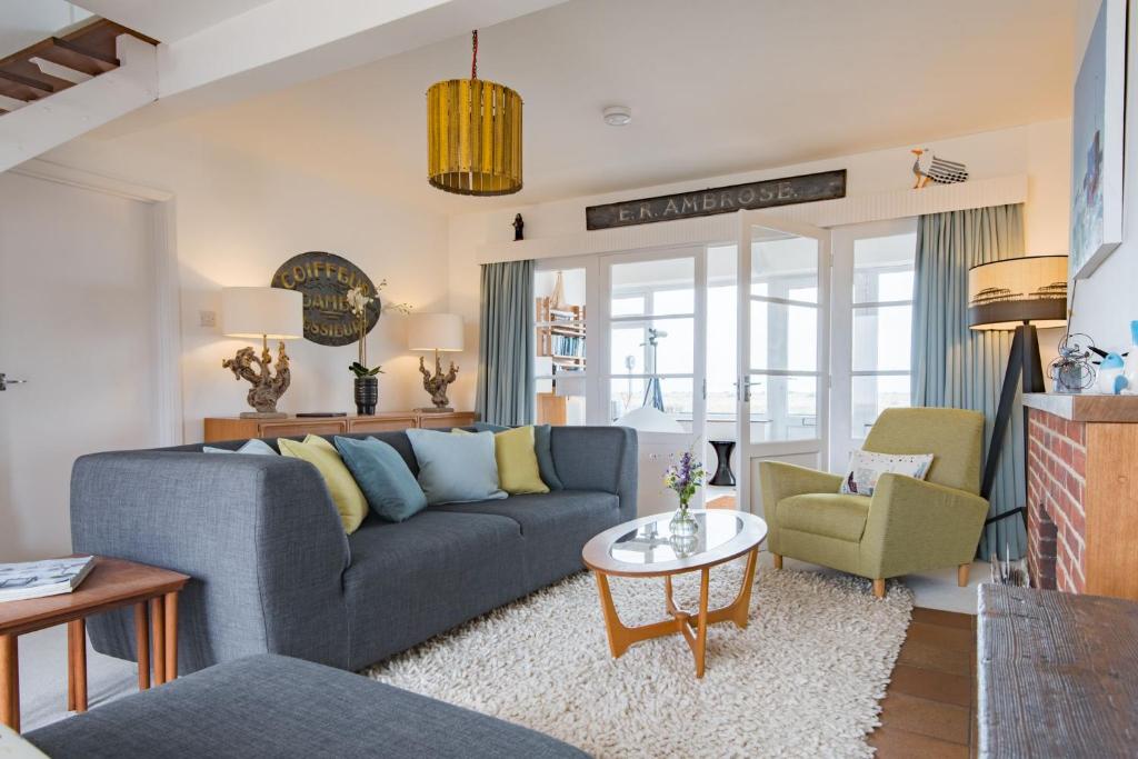 a living room with a blue couch and a table at The Buoys in Dungeness