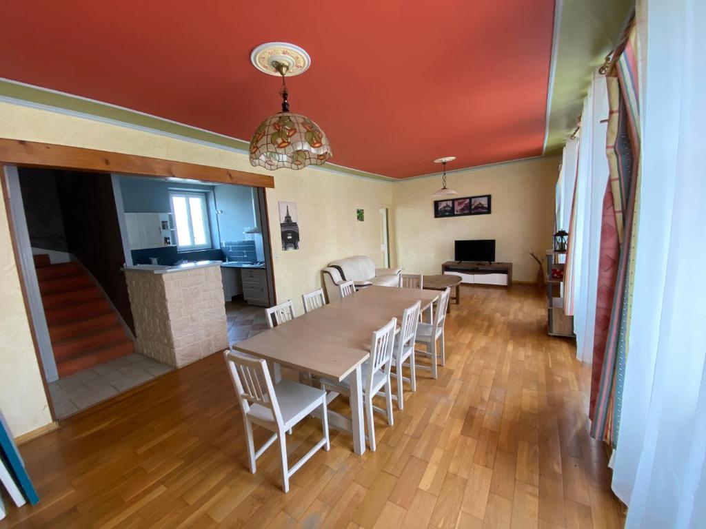 a dining room with a table and white chairs at Maeva in Pontorson