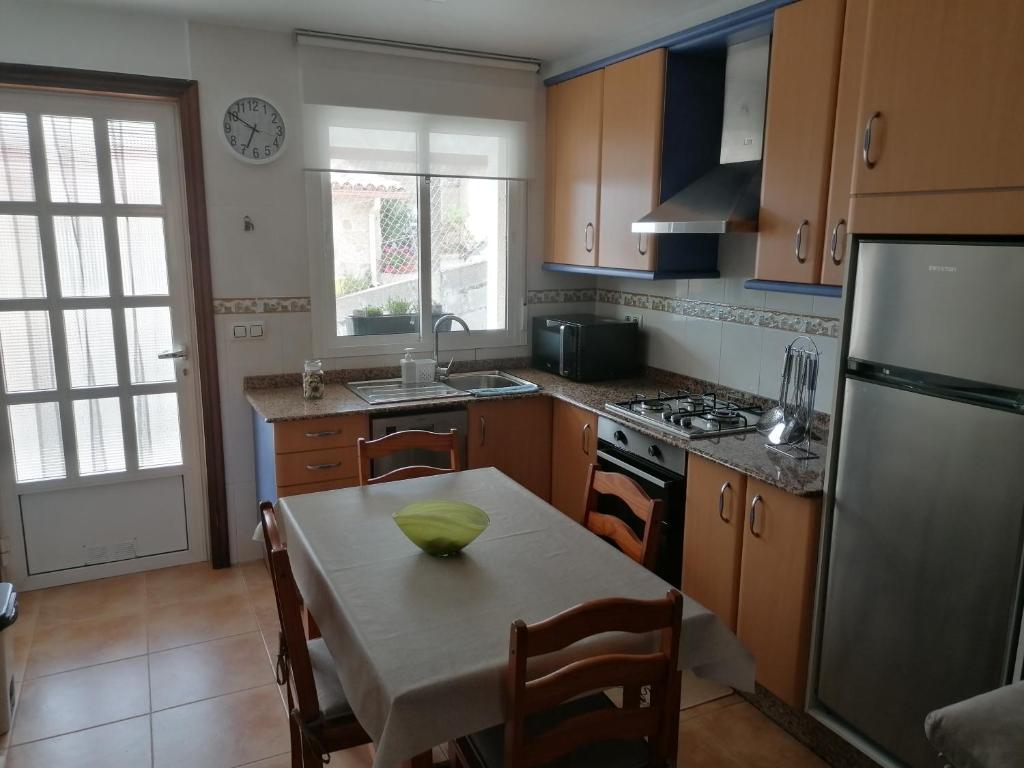 a kitchen with a table with a green bowl on it at La casita de Meiro in Bueu