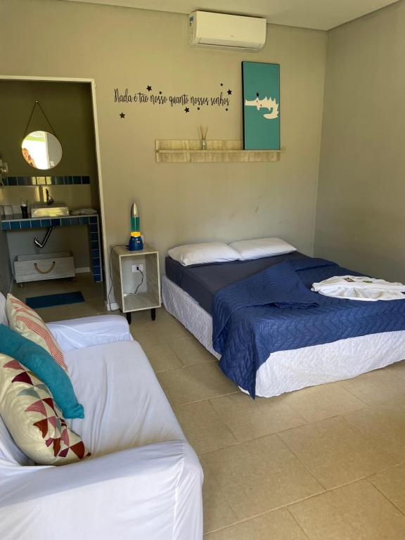 une chambre avec deux lits et un canapé dans l'établissement Pousada Villa São Francisco, à Boituva