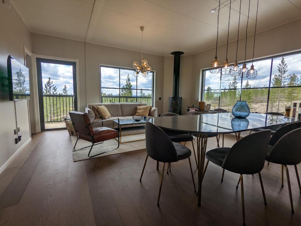 comedor y sala de estar con mesa y sillas en Poolorama Lodge - with magnificent mountain view, en Idre