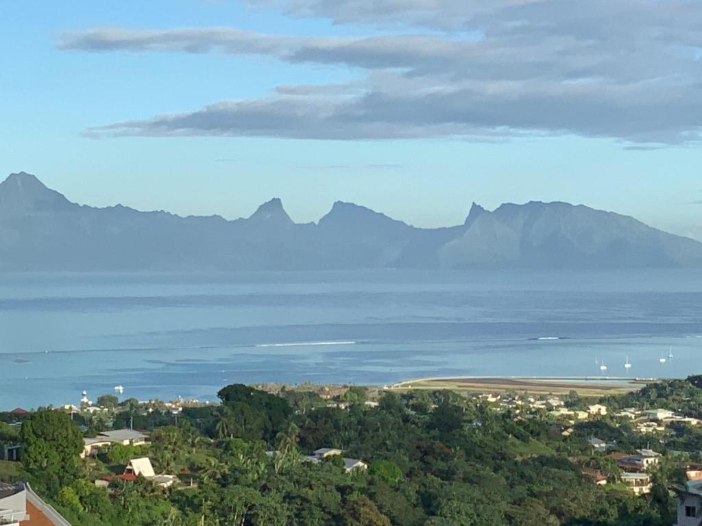 a view of the ocean with mountains in the background at Tahitininalodge 1 in Faaa