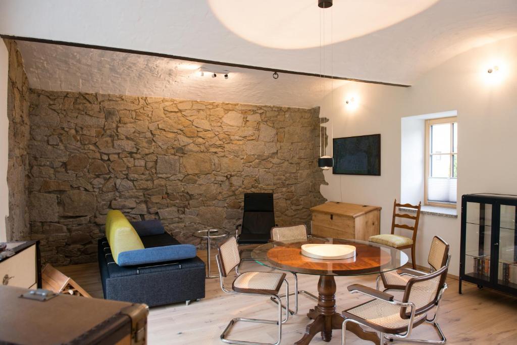 a living room with a table and a stone wall at Haflingerstall in Neudiehman