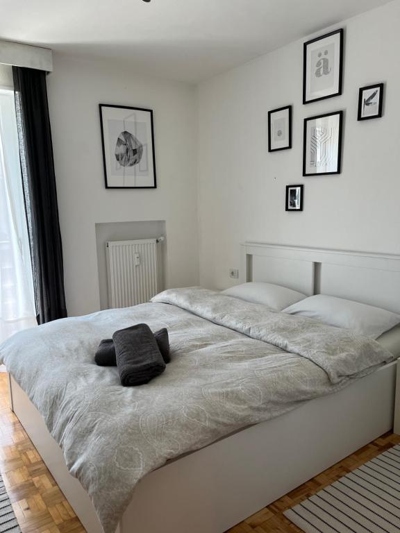 a white bedroom with a large bed with two pillows on it at M&M Apartment in Perca