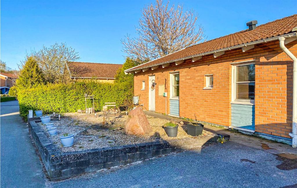 a brick house with potted plants in front of it at Awesome Home In karp With Kitchen in Åkarp