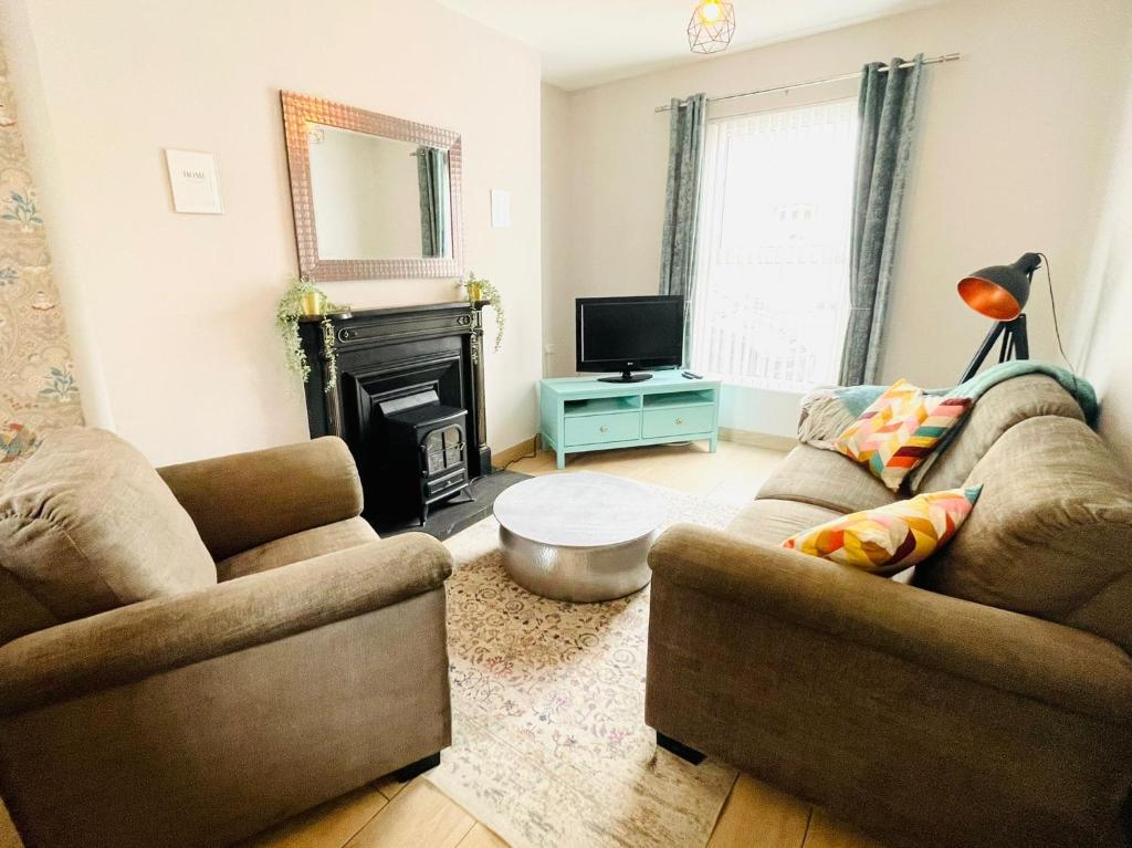 a living room with two couches and a fireplace at Calla's place in Derry Londonderry