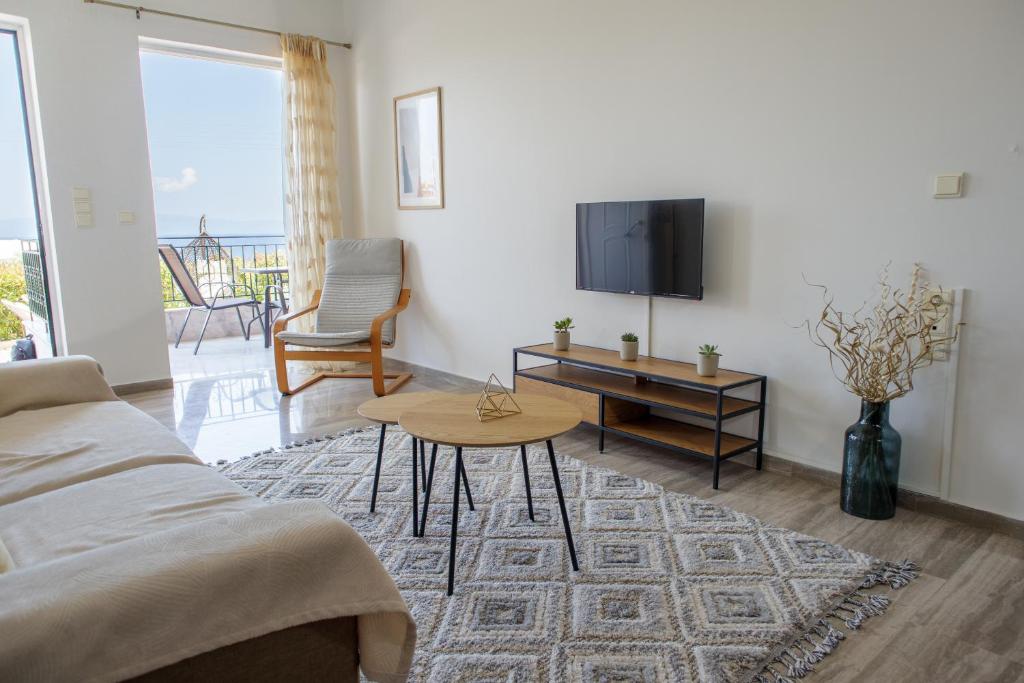 - un salon avec un canapé, une télévision et une table dans l'établissement Almyros Aktis seaview apartment, à Kalamata