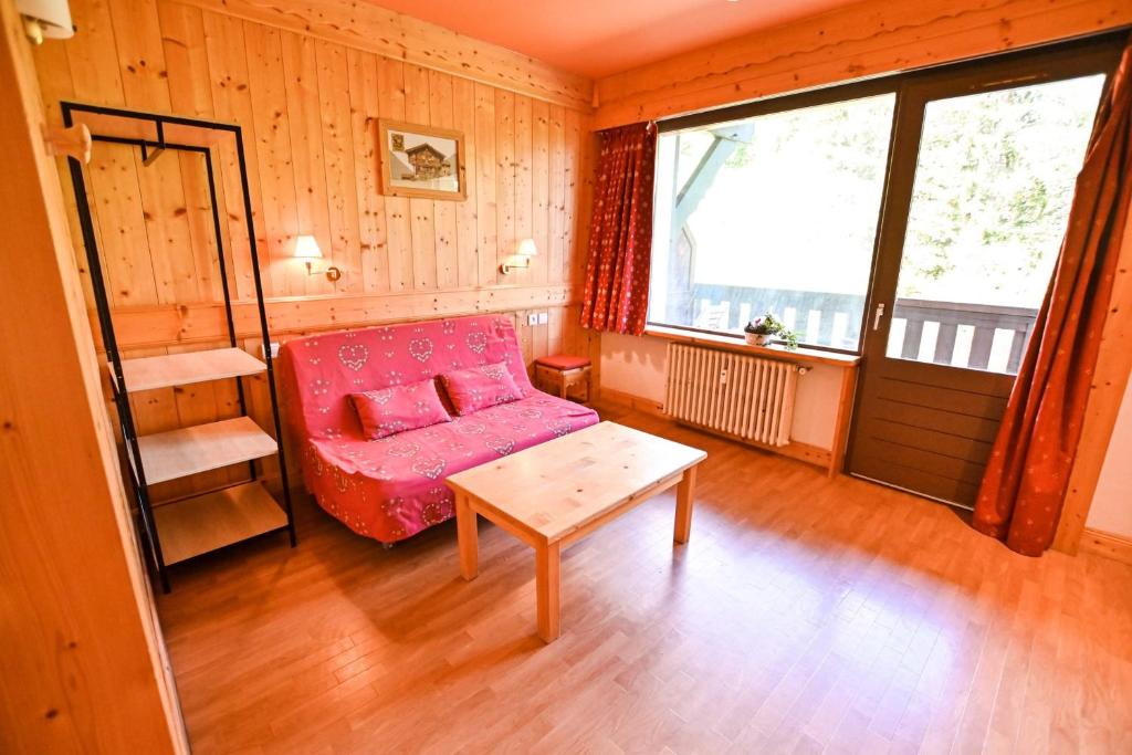 - un salon avec un canapé rose et une table dans l'établissement LUMINEUX studio avec BALCON à Combloux !, à Combloux