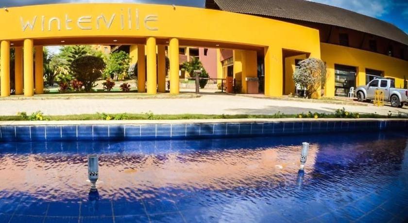a yellow building with a swimming pool in front of it at Flat 419 - Winterville-Gravatá in Gravatá