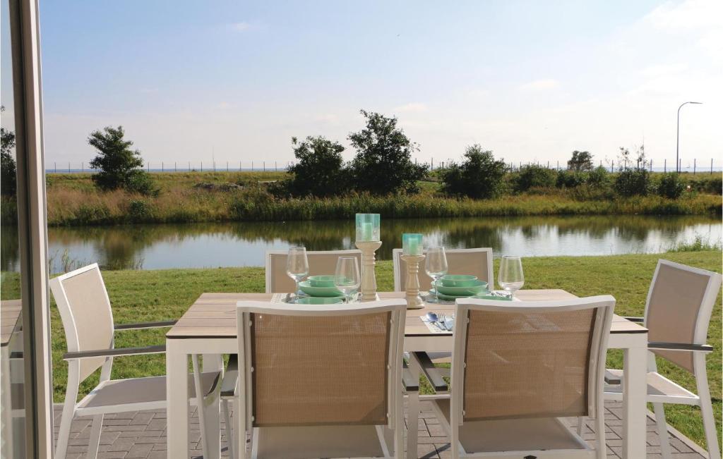 オルペニッツにあるLovely Home In Ostseeresort Olpenitz With Kitchenの湖の景色を望むテーブル(白い椅子付)