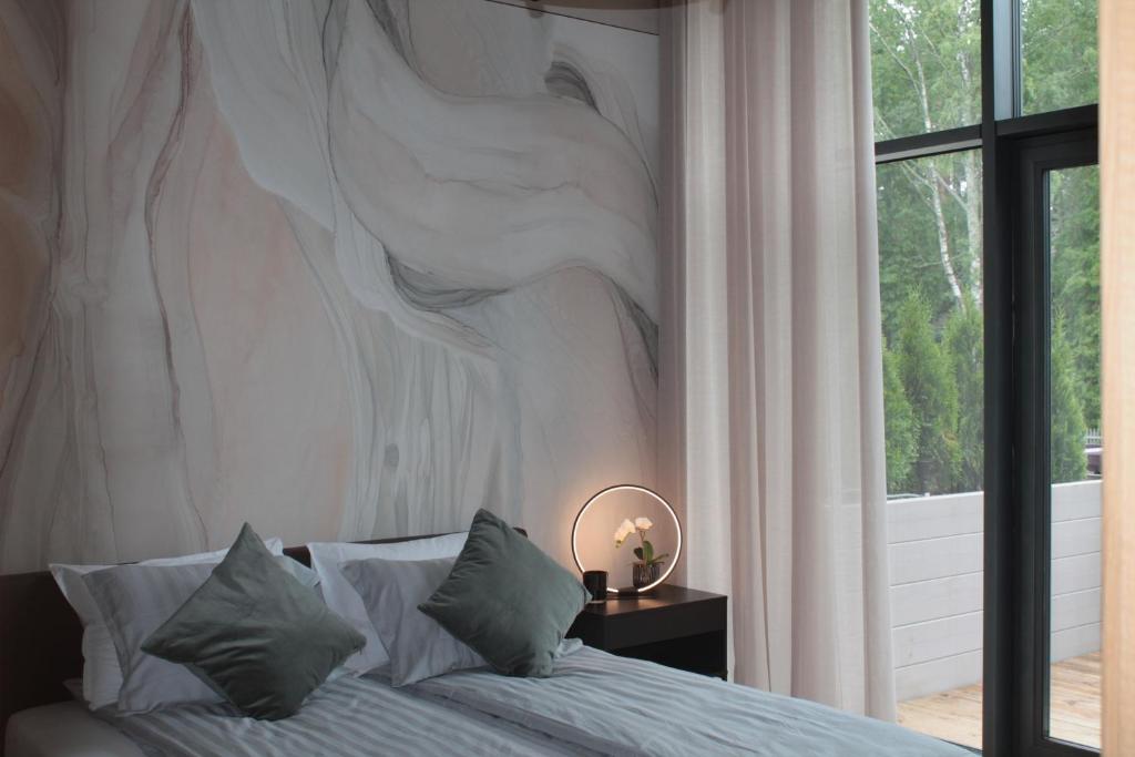 Schlafzimmer mit einem Bett mit Wandgemälde in der Unterkunft Green Valley Loft in Jūrmala