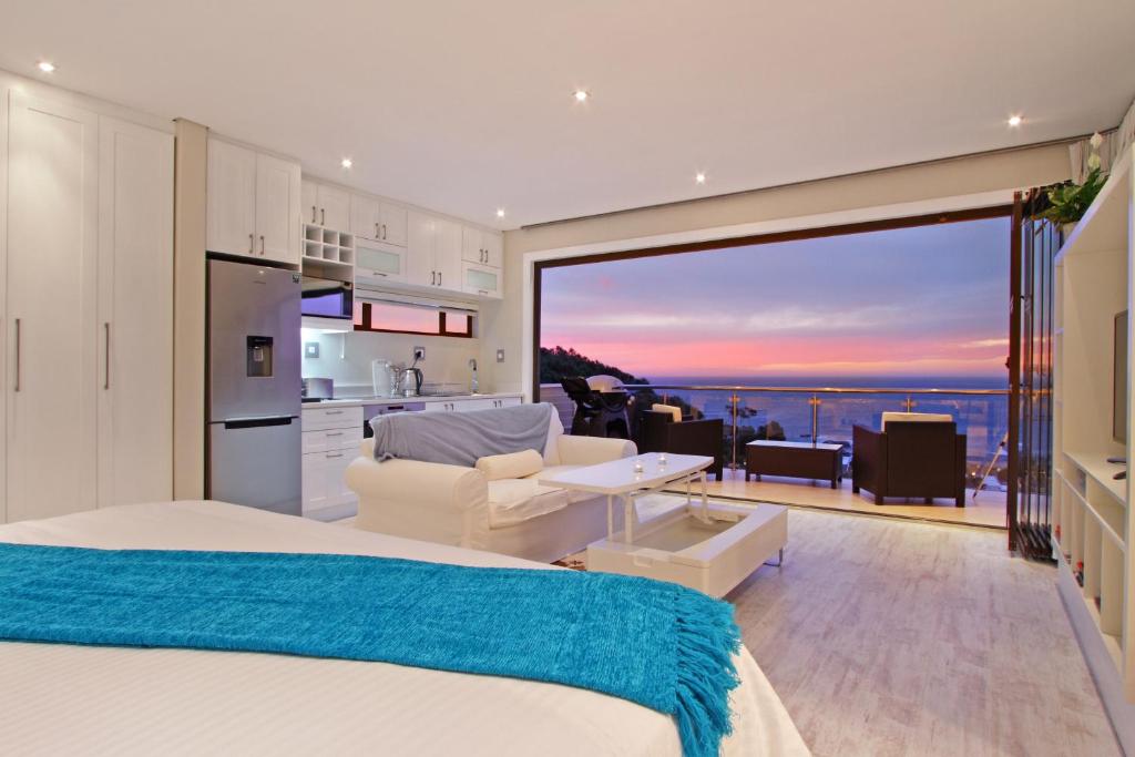 a bedroom with a bed and a kitchen with a view at Sea Mount in Cape Town