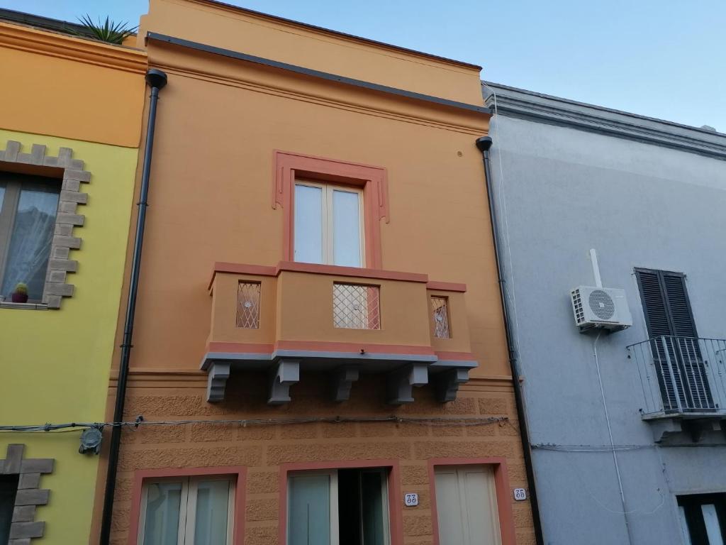 um edifício com uma varanda ao lado em Appartamento su palazzina storica in centro a Sant'Antioco em SantʼAntìoco