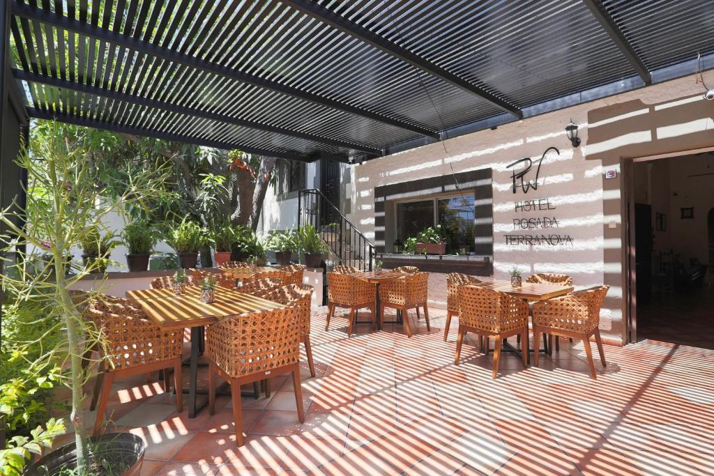 a patio with tables and chairs on a deck at Hotel Posada Terranova in San José del Cabo