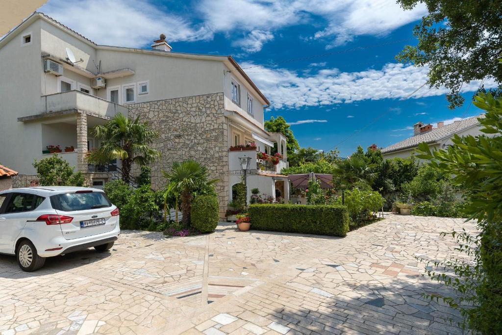 a white car parked in front of a house at Villa Feral Apartments in Crikvenica