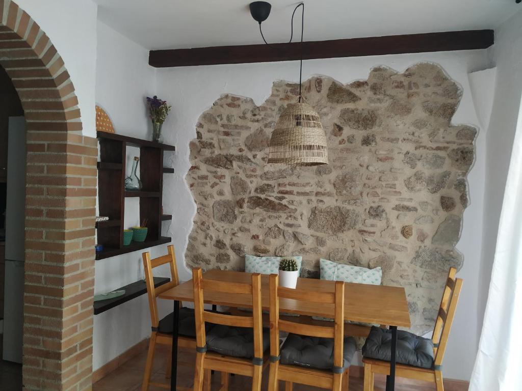 a dining room with a stone wall and a table and chairs at Pis a Sant Feliu de Guíxols in Sant Feliu de Guixols