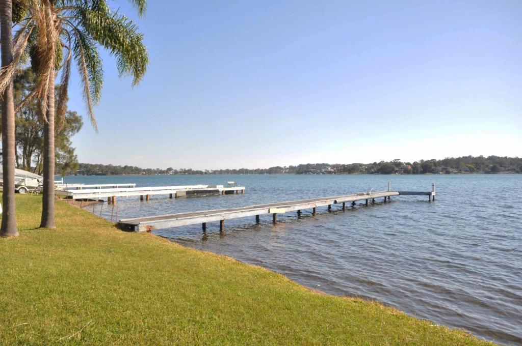 a dock on a body of water with palm trees at Fishing Point Shores in Fishing Point