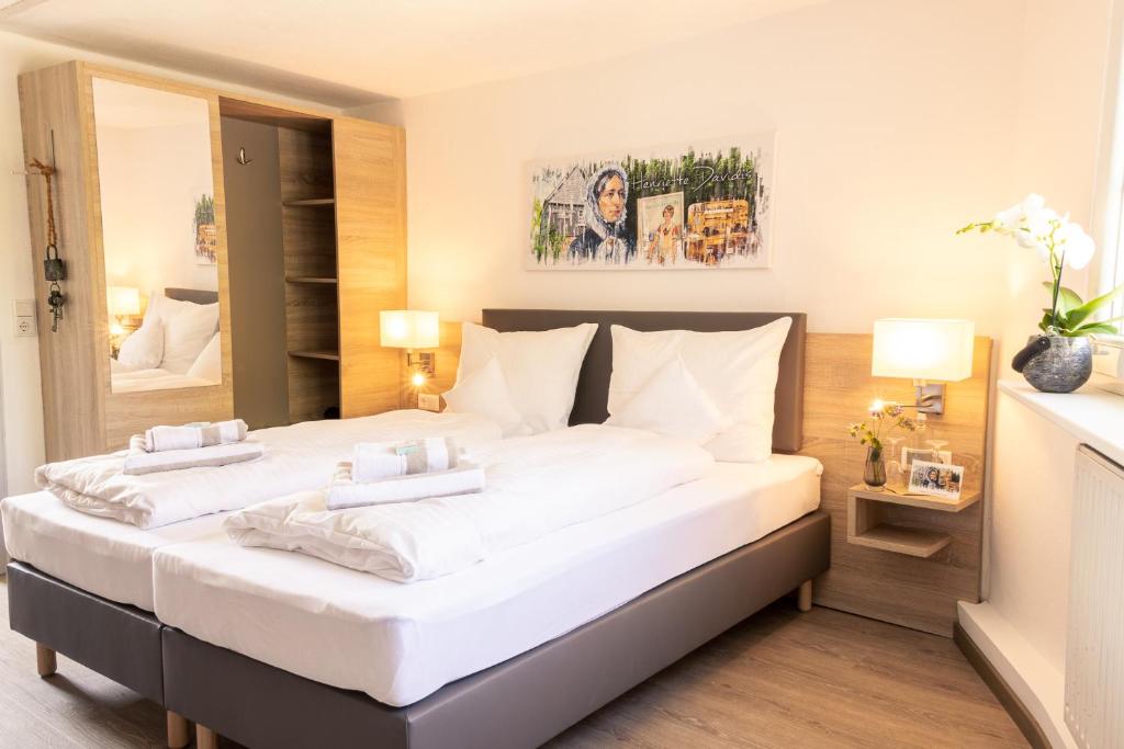 a bedroom with two beds with white sheets at HeimatHerz Hotel Garni in Herdecke