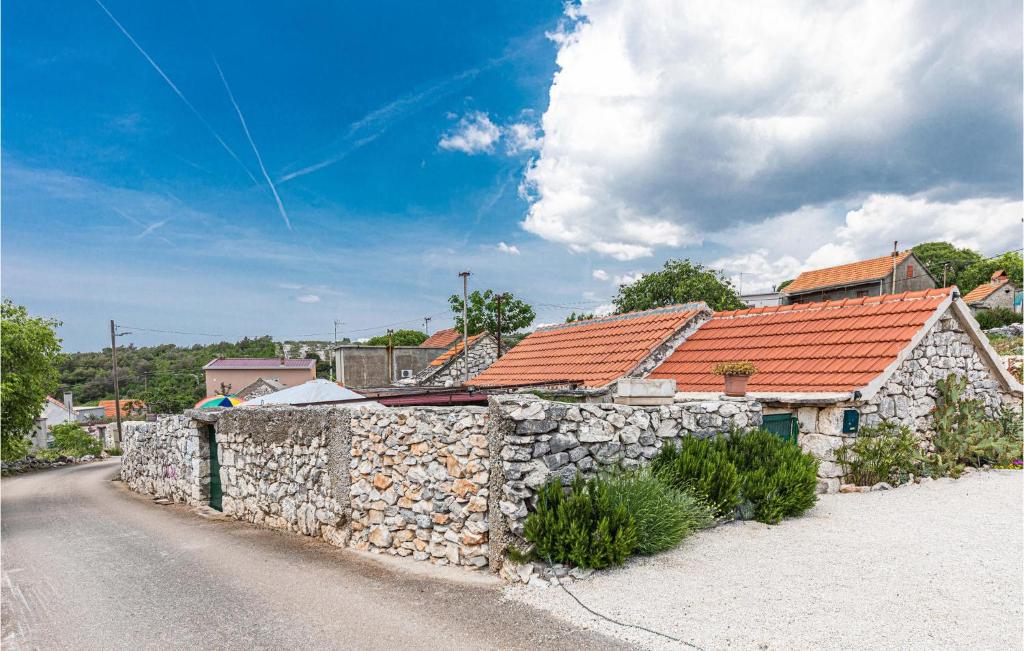un edificio in pietra con un muro di pietra accanto a una strada di Lovely Home In Blizna Donja With Kitchen a Blizna Donja