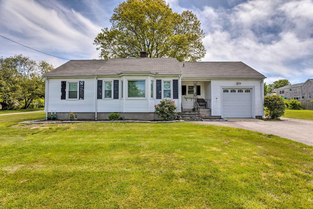 a white house with a garage on a lawn at Cozy Middletown Home Near Beaches and Newport! in Middletown