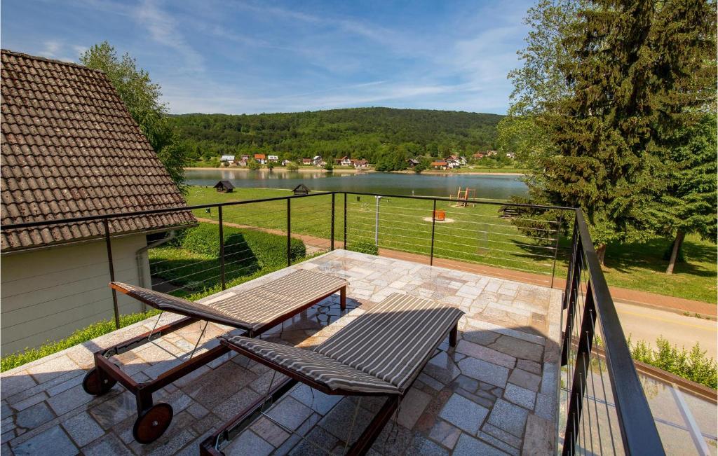 a patio with two chairs and a table and a view of a lake at Awesome Home In Ogulin With 1 Bedrooms, Jacuzzi And Wifi in Ogulin