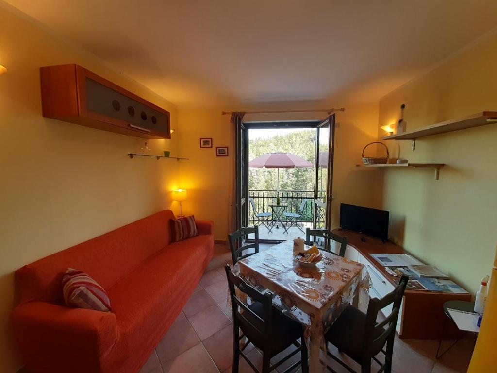 uma sala de estar com um sofá vermelho e uma mesa em Terrazza su Fosso Bianco em Bagni San Filippo