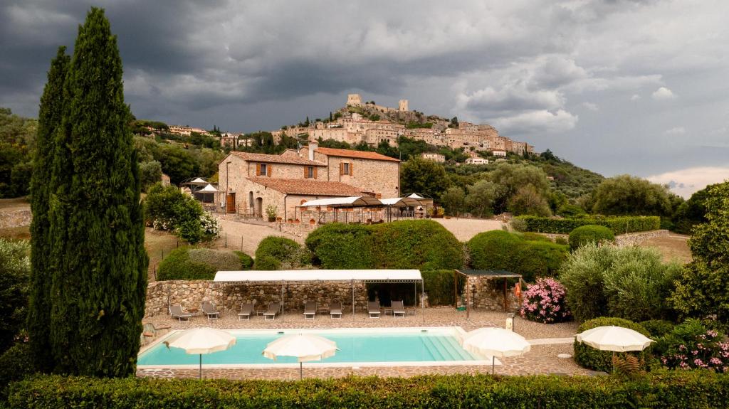 eine Villa mit einem Pool vor einem Haus in der Unterkunft Tenuta Montemassi Podere Montauzzo in Montemassi