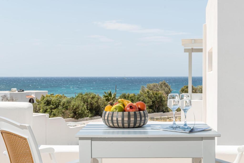 a basket of fruit on a table with a view of the ocean at Elma Kastraki with Pool in Kastraki Naxou