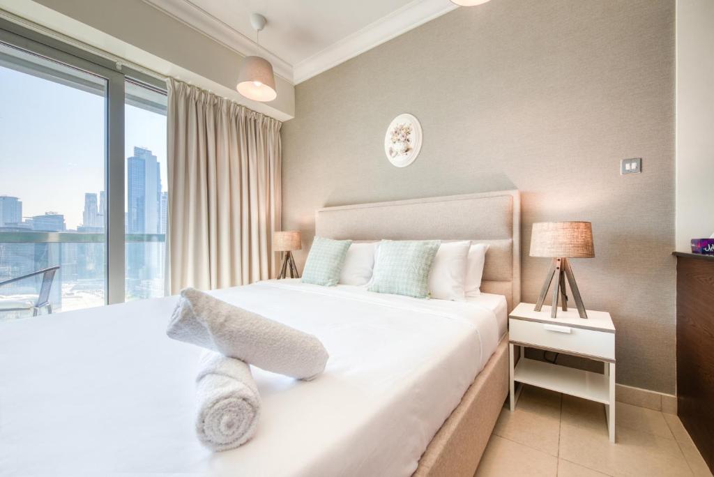 a hotel room with a large bed and a large window at Prime Retreats - Downtown Dubai in Dubai