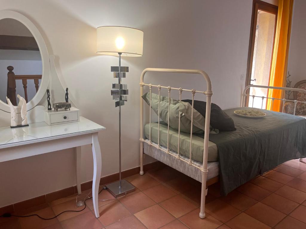 - une chambre avec un lit doté d'une lampe et d'un miroir dans l'établissement Le Mazet de choubouloute, à Saint-Gilles