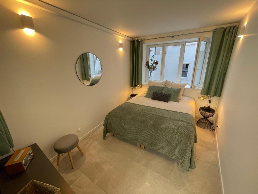 ein kleines Schlafzimmer mit einem Bett und einem Fenster in der Unterkunft Loft central climatisé avec verrière in Vernon