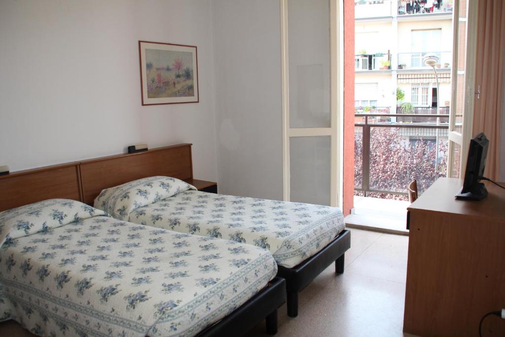 a bedroom with two beds and a window with a balcony at Nuovo Hotel San Martino in Casalecchio di Reno