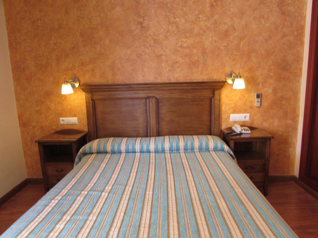 a bedroom with a bed with two nightstands at PARAISO PLAYA Hotel in Isla Cristina
