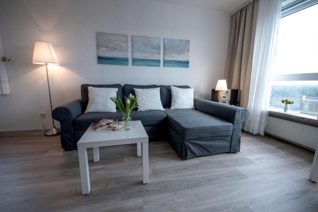 een woonkamer met een bank en een tafel bij Frische-Brise-10-01 in Cuxhaven