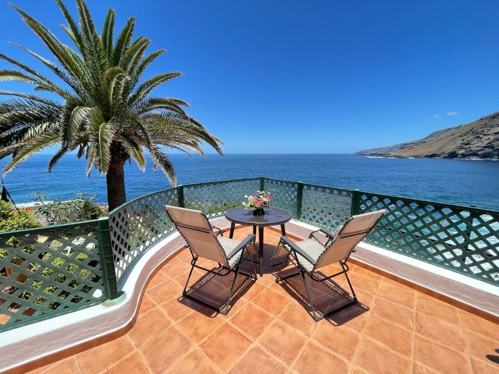 a balcony with a table and chairs and the ocean at Trinimat Ferienhaus am Meer Teneriffa Nord 1 in La Matanza de Acentejo
