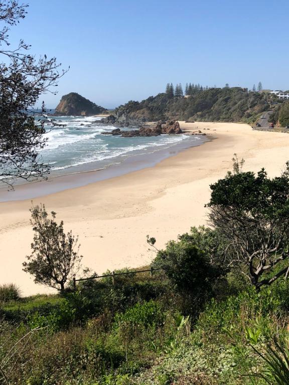 einen Sandstrand mit dem Ozean im Hintergrund in der Unterkunft Fi's Beach House in Port Macquarie