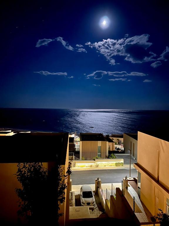 a car parked in a parking lot in front of the ocean at Royal Paradise Green Coast Resort Palase in Vlorë