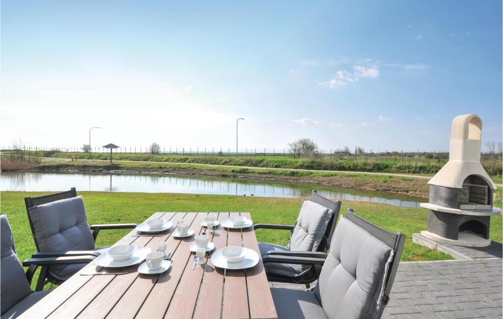 einen Holztisch und Stühle mit Flussblick in der Unterkunft Strand-lodge in Olpenitz