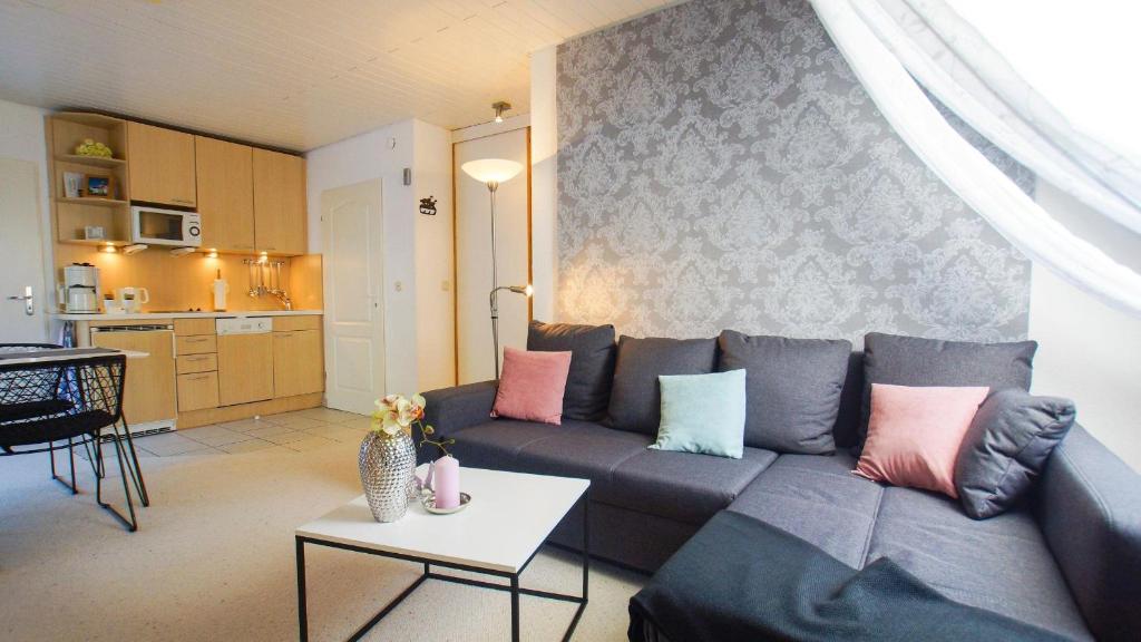 ein Wohnzimmer mit einem Sofa und einem Tisch in der Unterkunft Am Flockengrund 26a/4 OG in Cuxhaven