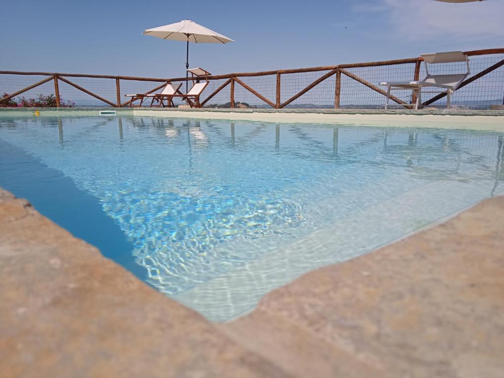 基昂尼的住宿－LA CASA DI CHIANNI La Pieve 2，一个带遮阳伞和椅子的游泳池