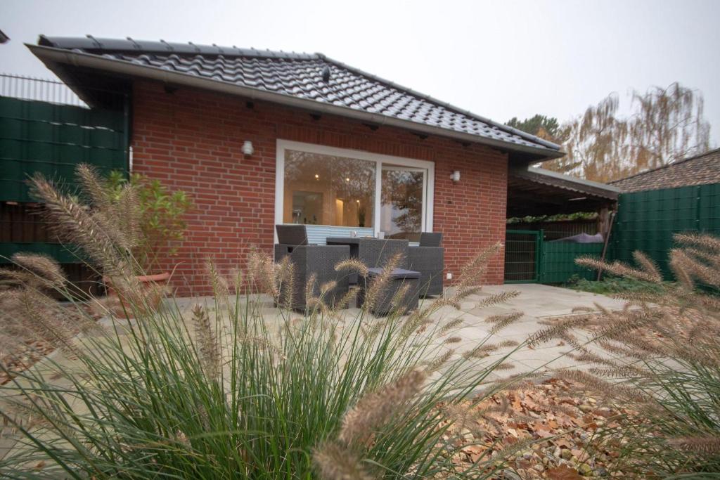 una casa de ladrillo con una mesa y sillas en un patio en Im-Wiesengrund, en Cuxhaven