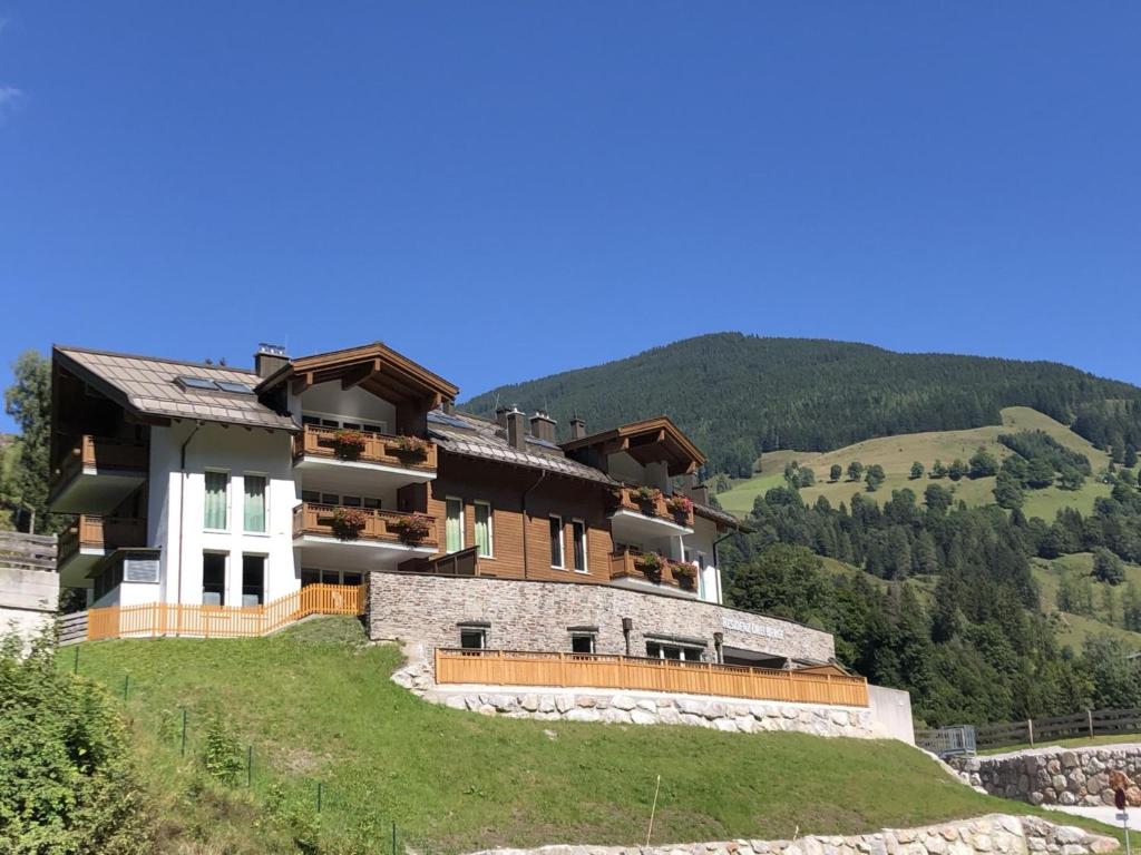 duży budynek na wzgórzu z górami w tle w obiekcie Glemmtal w Saalbach Hinterglemm
