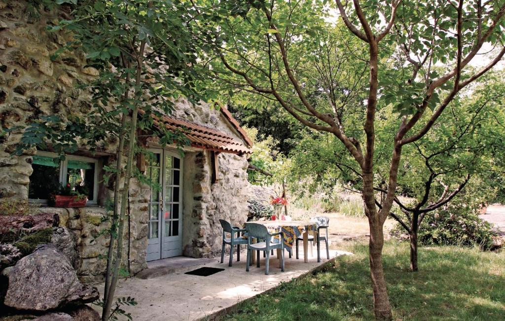 a table and chairs in front of a stone house at 1 Bedroom Amazing Home In Mayres in Mayres