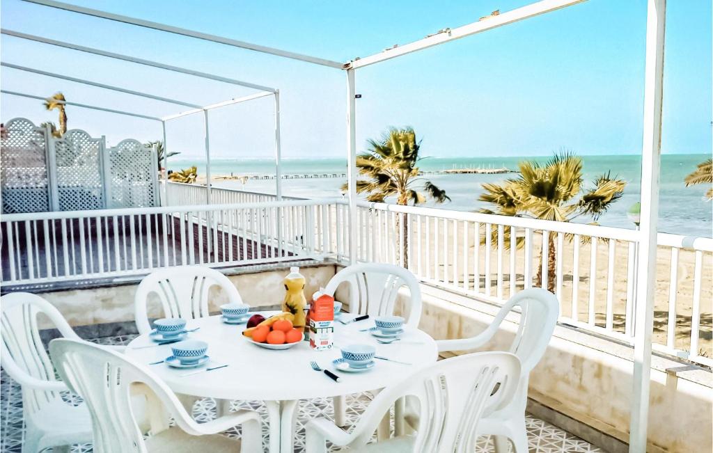 uma mesa branca e cadeiras numa varanda com praia em Nice Apartment In Los Urrutias With Wifi em Los Urrutias