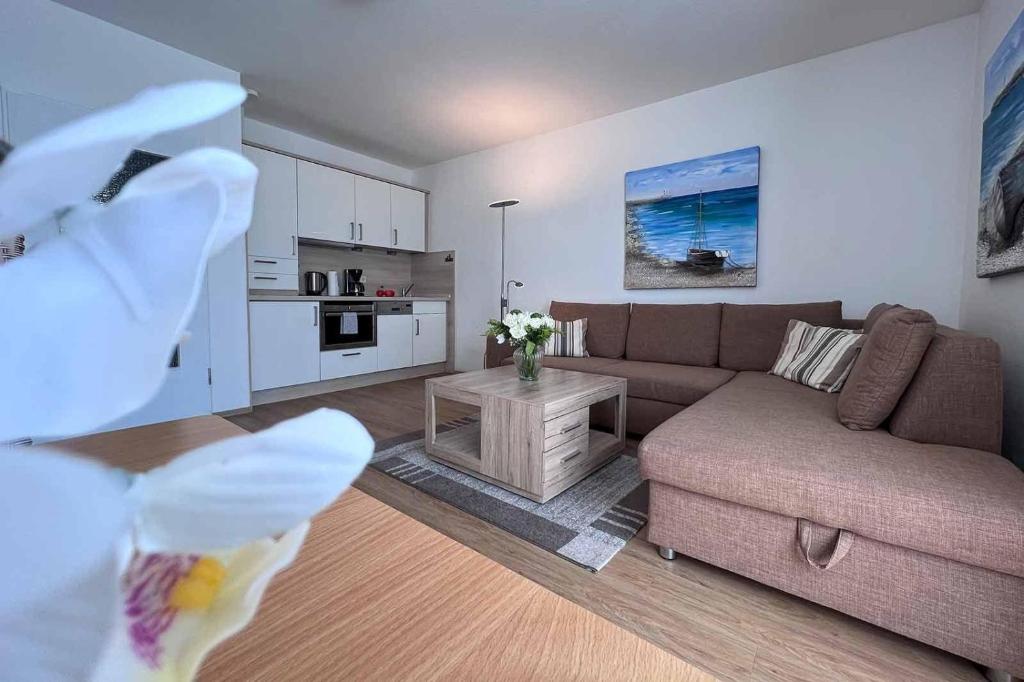 uma sala de estar com um sofá e uma mesa em Ferienwohnung-47-mit-Schwimmbad-Sauna-Residenz-Passat-Doese em Cuxhaven