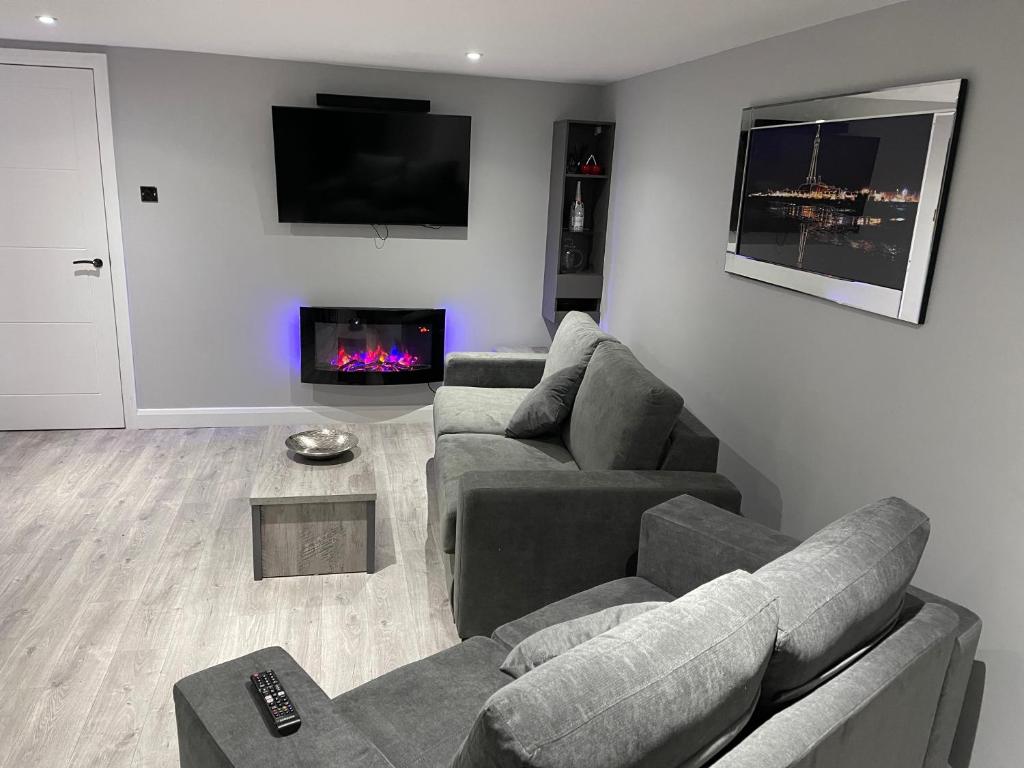 a living room with two couches and a fireplace at The Welcome Apartment in Blackpool