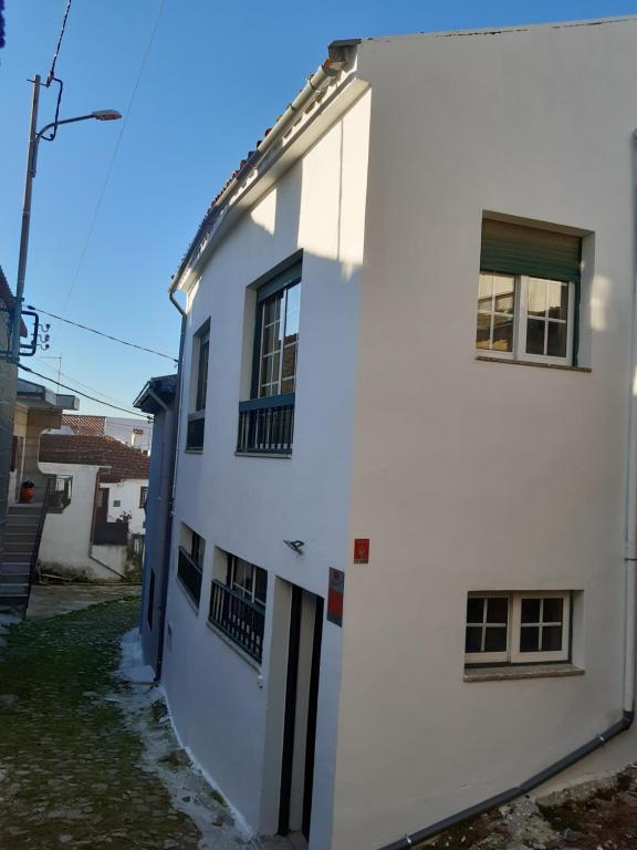 un edificio bianco con due finestre e una porta di D'ouro Relax a Sanfins do Douro