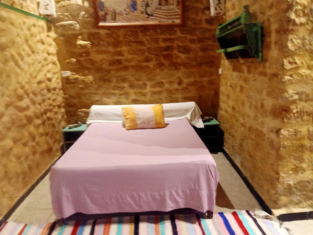 a bedroom with a bed with white sheets and yellow pillows at 2 bedrooms apartement with city view furnished terrace and wifi at Tunis 4 km away from the beach in Tunis