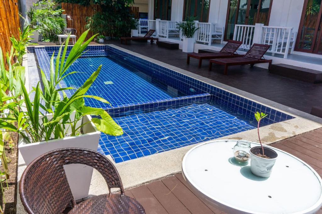 a swimming pool with a table and chairs next to it at Isla Tortuga Diving & Hostel in Ko Tao