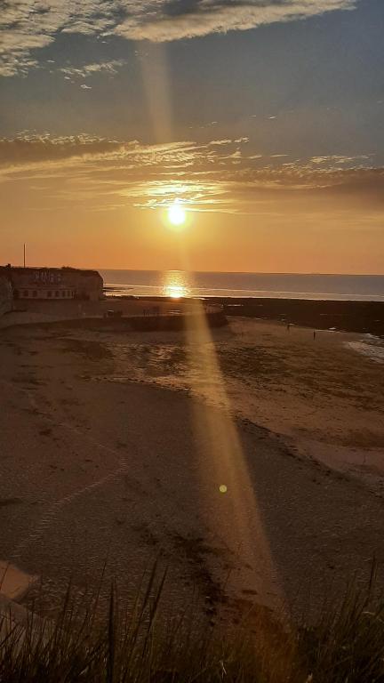 a sunset on a beach with the sun setting at Home from Home Stay Margate in Margate